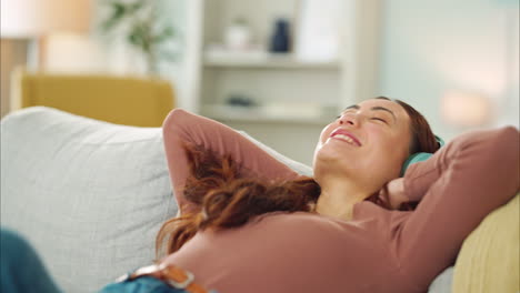 mujer, teléfono o auriculares de música en el sofá de relajación