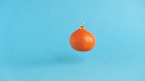 flying swirling christmas toy made from orange tangerine fruit. minimal new years concept. levitation