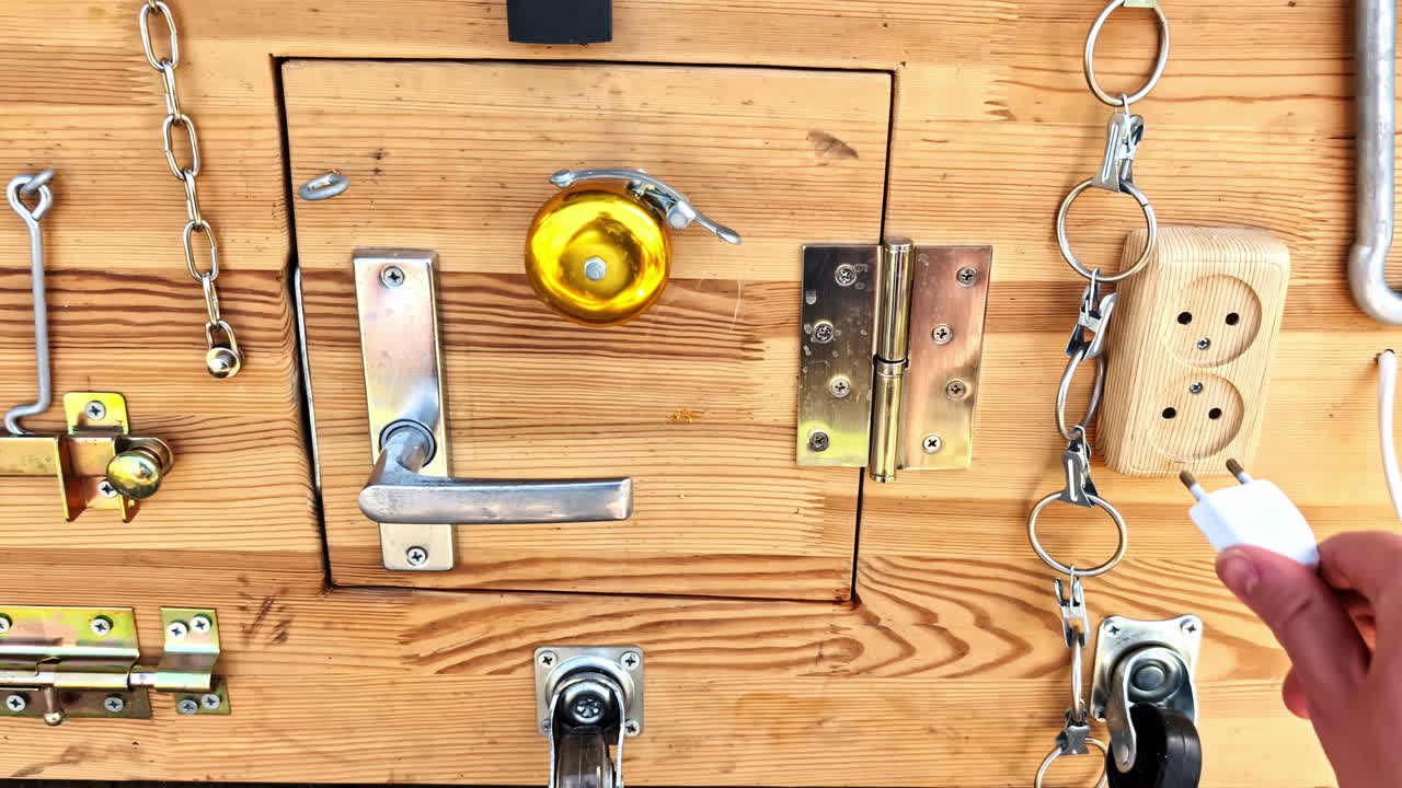 POV of training tasks on Wooden latch board with locks, hinges and handles