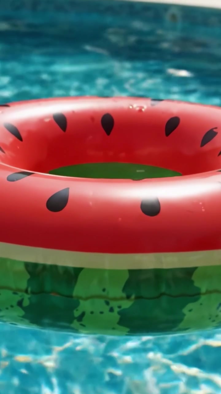 A Vibrant Watermelon Float Ring Gliding Across a Sparkling Pool, Perfect for Summer Fun and Relaxation on a Sunny Day