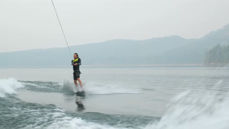 Vorderansicht-Eines-Kaukasischen-Jungen-Mannes,-Der-Tricks-Auf-Dem-Wakeboard-Im-Stadtfluss-Macht,-4k