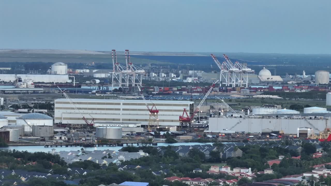 Industrial port of Tampa with cranes and buildings in Florida. Aerial wide shot. Housing area in foreground. Panorama view.