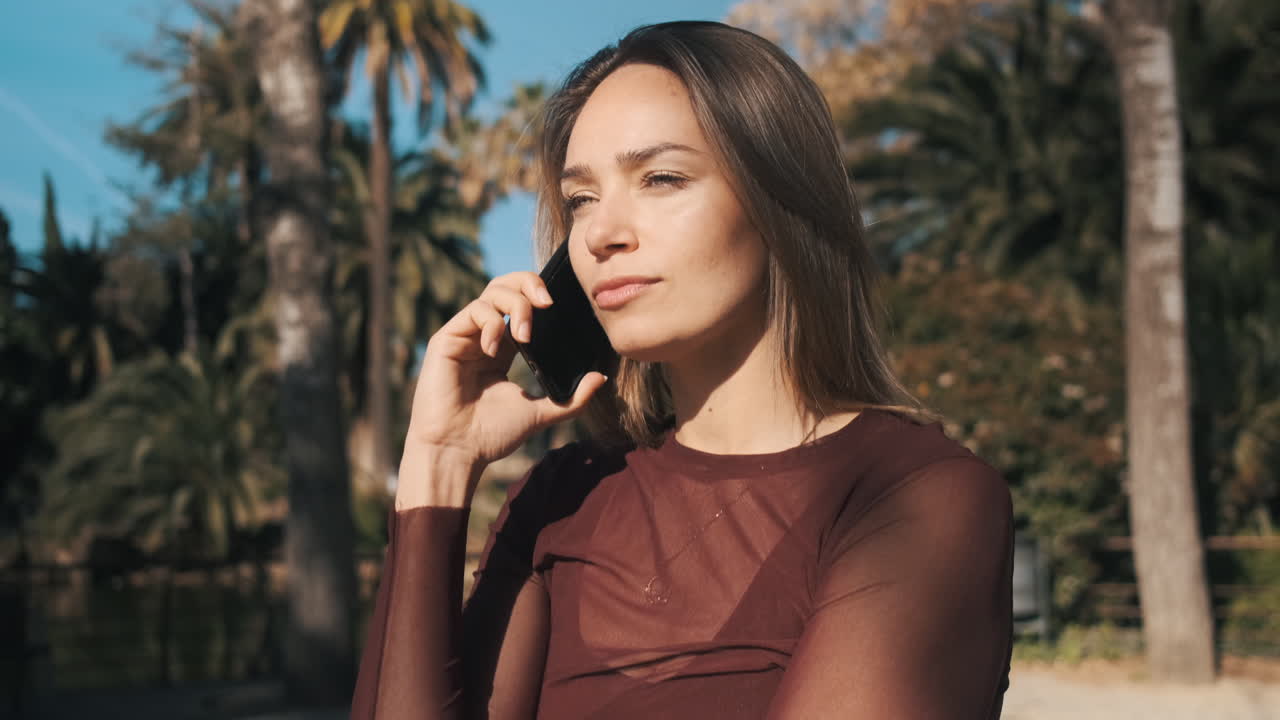 젊은 여성이 야외에서 스마트폰을 사용하고 있습니다.