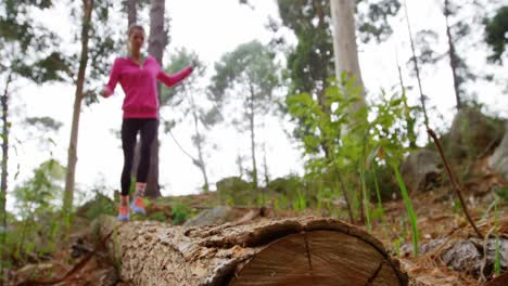 woman running on a tree trunk