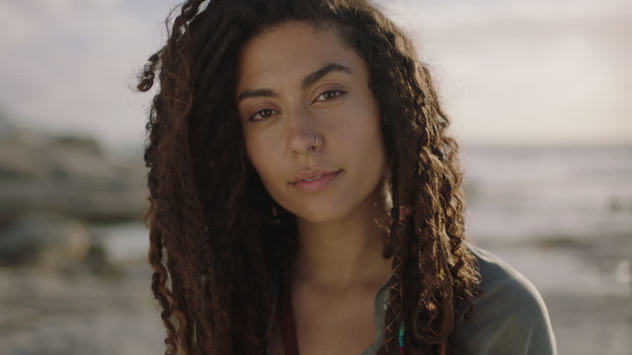 retrato de uma bela mulher hispânica independente com dreadlocks olhando pensativo pensativo na praia