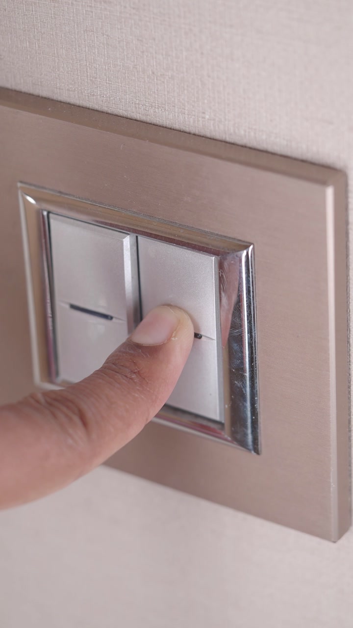 Close-up of Hand Turning Light Switch On and Off