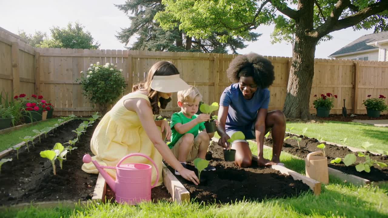 Planting trio, yellow dress guiding child holding plug, digging in backyard bed pink watering can