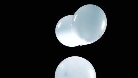 a collection of light blue balloons floats downwards, descending gently in a dreamlike manner. the soft, airy balloons create a calming, peaceful atmosphere as they drift slowly toward the ground.