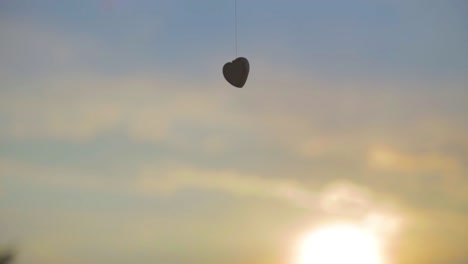 ornamento en forma de corazón volando en el cielo al atardecer