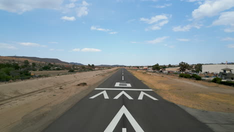 aerial drone shot circling runway numbers showcasing runway at a small general aviation airport and surrounding area