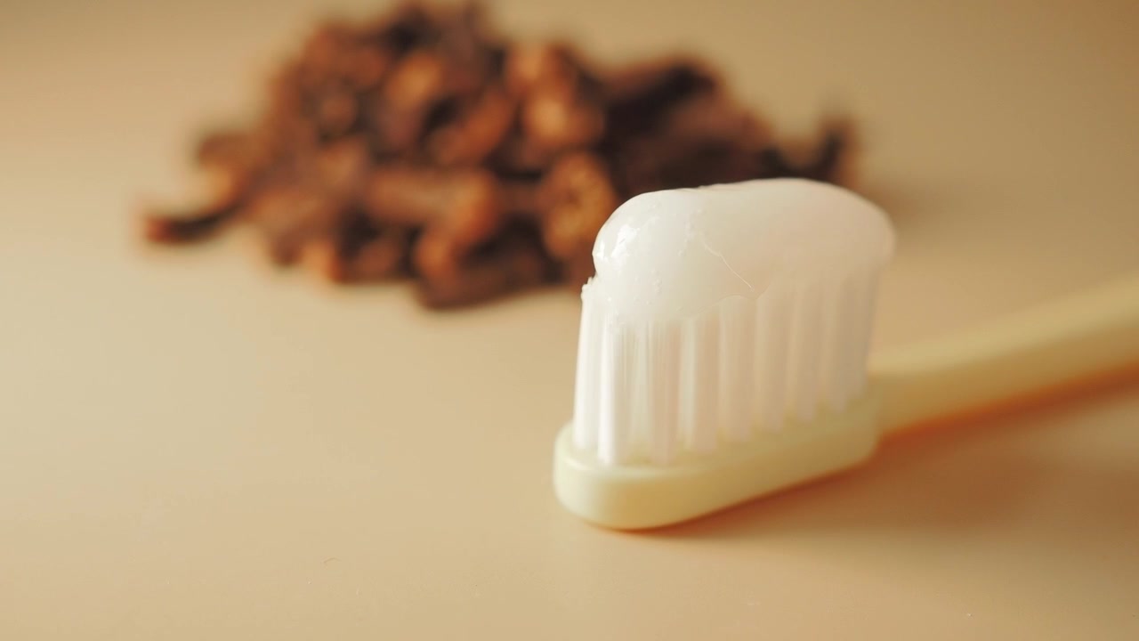 Toothbrush with Toothpaste and Natural Miswak Sticks in Background