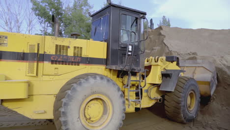 yellow wheel loader loading sand