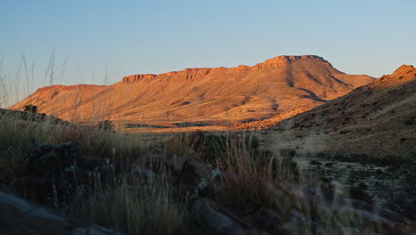 picturesque view of arid karoo landscape with mountainside lit up at sunset