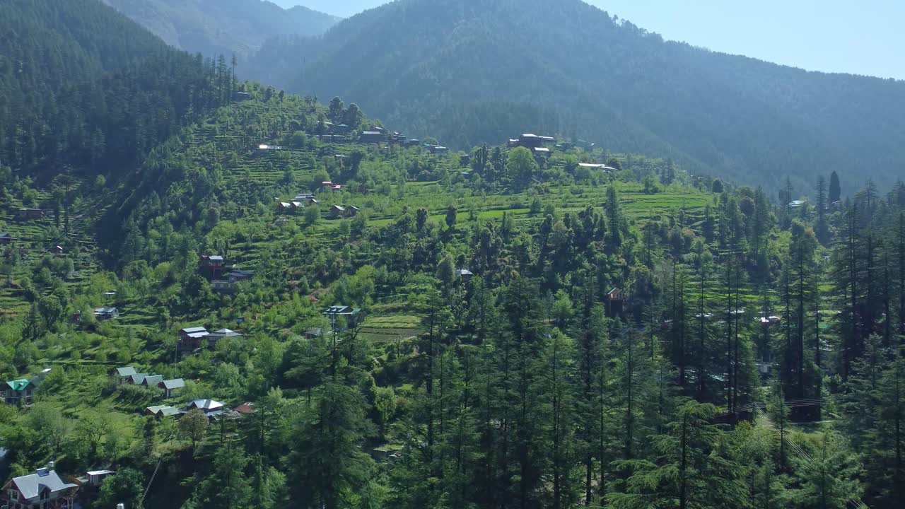 Aerial view short of Jibhi Himachal Pradesh in India. Houses and trees in the mountainous area. Faguli festival is one of the biggest festival in Jibhi. The traditional houses here have stone roofs.