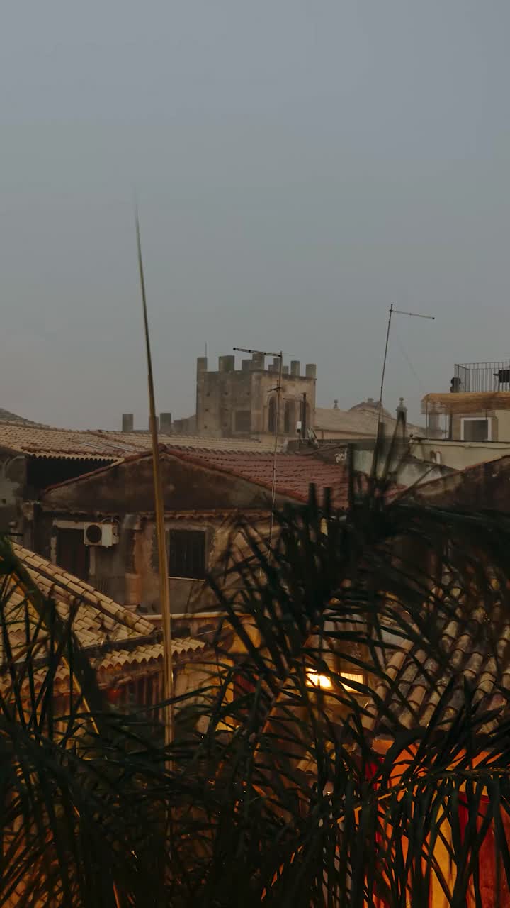 Vista verticale da una finestra su edifici storici in un cortile. Timelapse di un temporale in arrivo la sera. Isola di Ortigia in Sicilia
