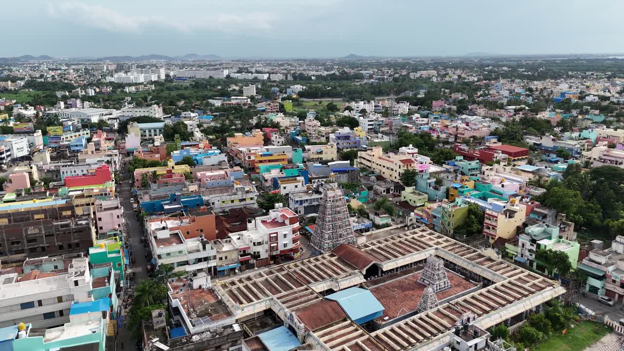 Busy South Indian city aerial featuring a historic Sri Kamakshi Amman Temple Chennai, Mangadu and Theppakulam dominating the foreground against a backdrop of colorful, dense urban development