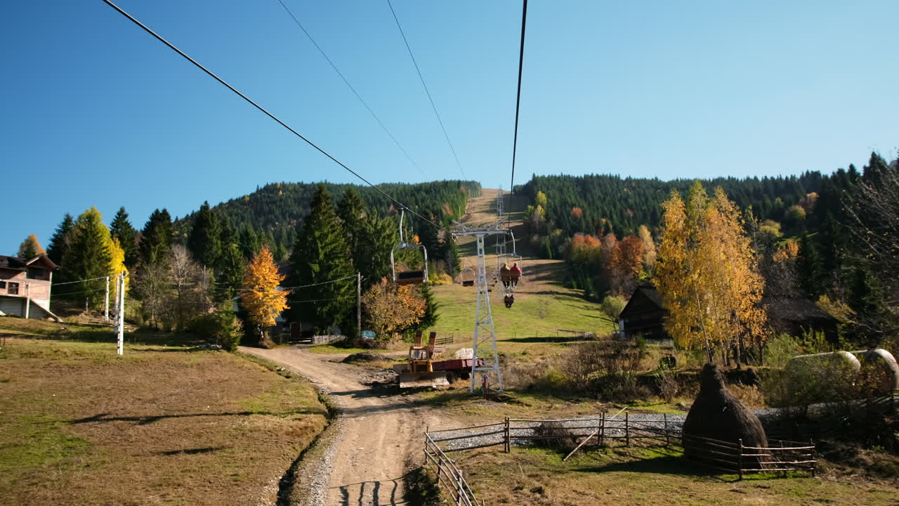 Funivia nei Carpazi, villaggio nella valle, colline ricoperte di vegetazione, Romania