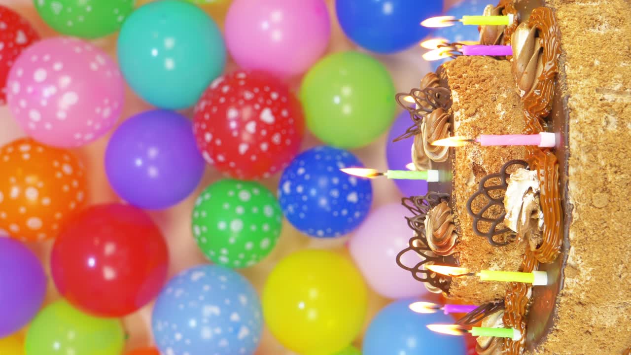 pastel de cumpleaños con globos de colores en el fondo