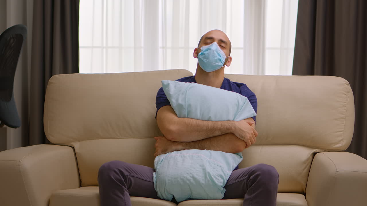 Hombre triste sosteniendo una almohada