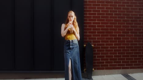 woman enjoying a drink outdoors with a skateboard