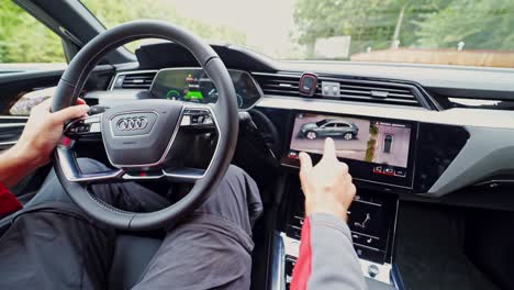 Inside view of a new electric car. Driver's hands on the steering wheel of audi e tron.