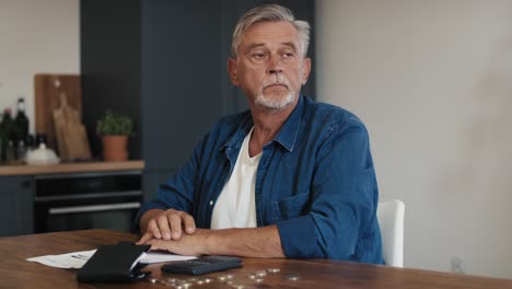 Caucasian senior man counting home budget using calculator.