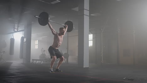 a young male weightlifter lifts a heavy barbell over his head performing a jerk. the jerk of a heavy barbell in slow motion