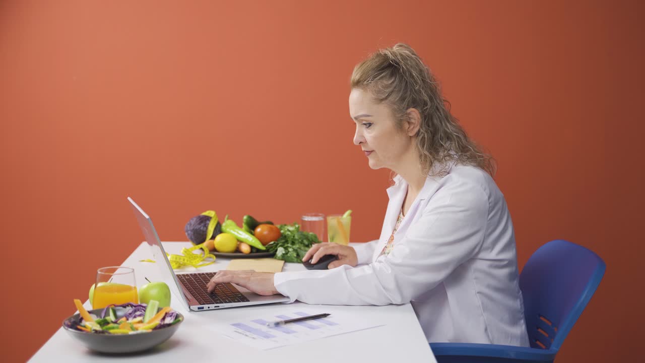 dietista preparando un plan de dieta en su computadora portátil.