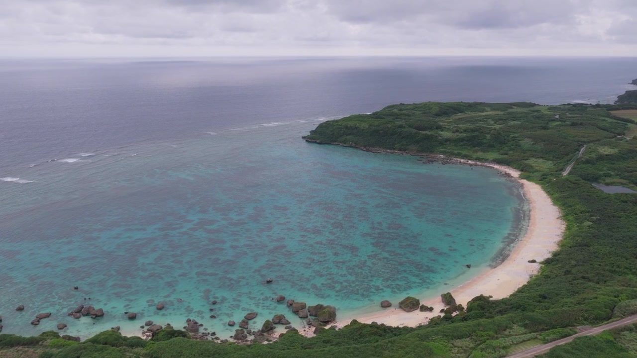 Japonya, Miyakojima, Okinawa'daki Hennasaki Deniz Feneri, Bora Balıkçı Limanı ve Maibah Plajı üzerinde sağa doğru sürüklenip sola kaydırılırken ileri doğru dolly hareketiyle çekilen yatay havadan çekimler