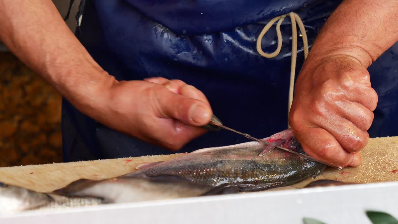 hombre preparando pescado fresco en el mercado