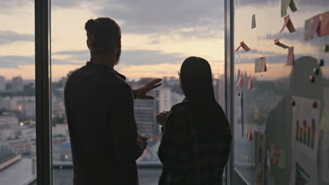 Dark-silhouette-couple-relaxing-in-evening-office-close-up.-Colleagues-talking