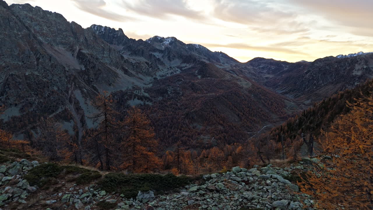 Rocky mountains in autumn under a colorful sunset sky
