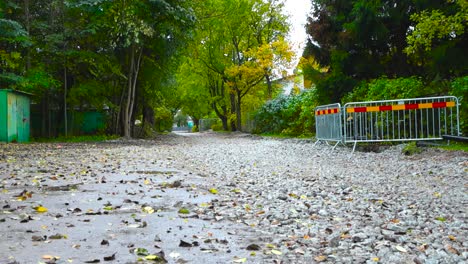 road under construction with gray gravel on the ground during autumn time day light in laagri or pääsküla estonia. rainy day with rain fall in slow motion on the puddles on the muddy brown ground.