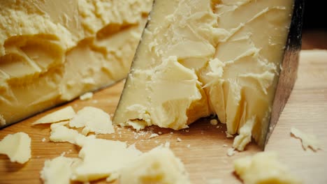 medium hard cheese head parmesan on wooden board. dolly-out shot