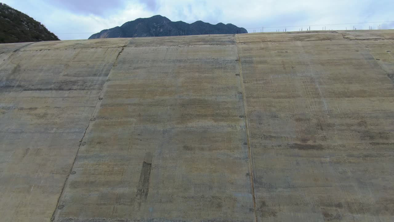 Concrete texture of dam standing between rocky slopes with mountains background in Monterrey, Mexico