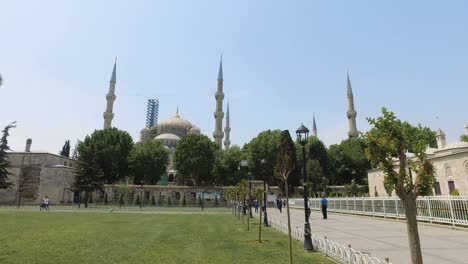 blue mosque and walking people in sultan ahmet park