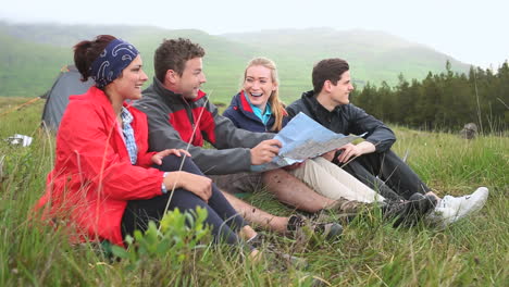 amigos en un viaje de campamento riendo juntos y leyendo el mapa