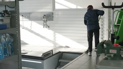 worker cleaning auto repair workshop