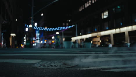 steam rising from manhole cover on a nyc street at night