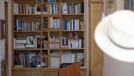 Slow-establishing-shot-of-a-bookshelf-and-antique-ladder-within-a-home-office