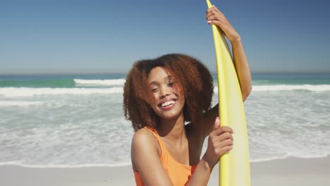 african american holding her surfboard