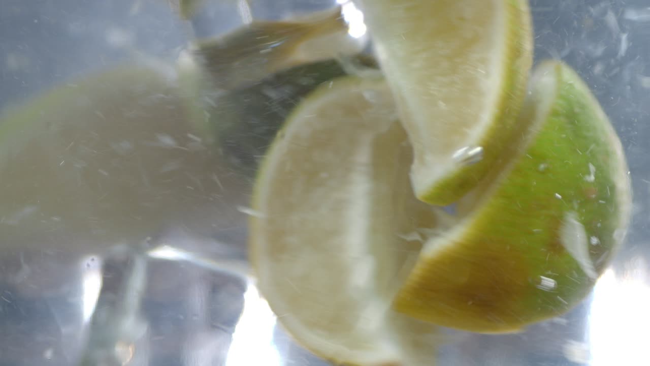 las rebanadas de cal se mezclan bajo el agua con pedazos de hielo.