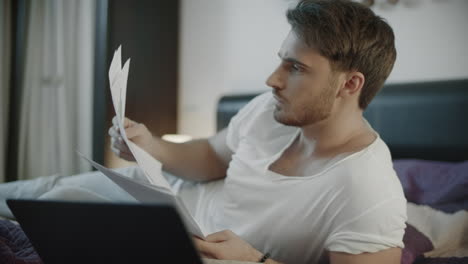 Business-man-working-with-papers-on-sofa-at-evening.-Focused-businessman-working