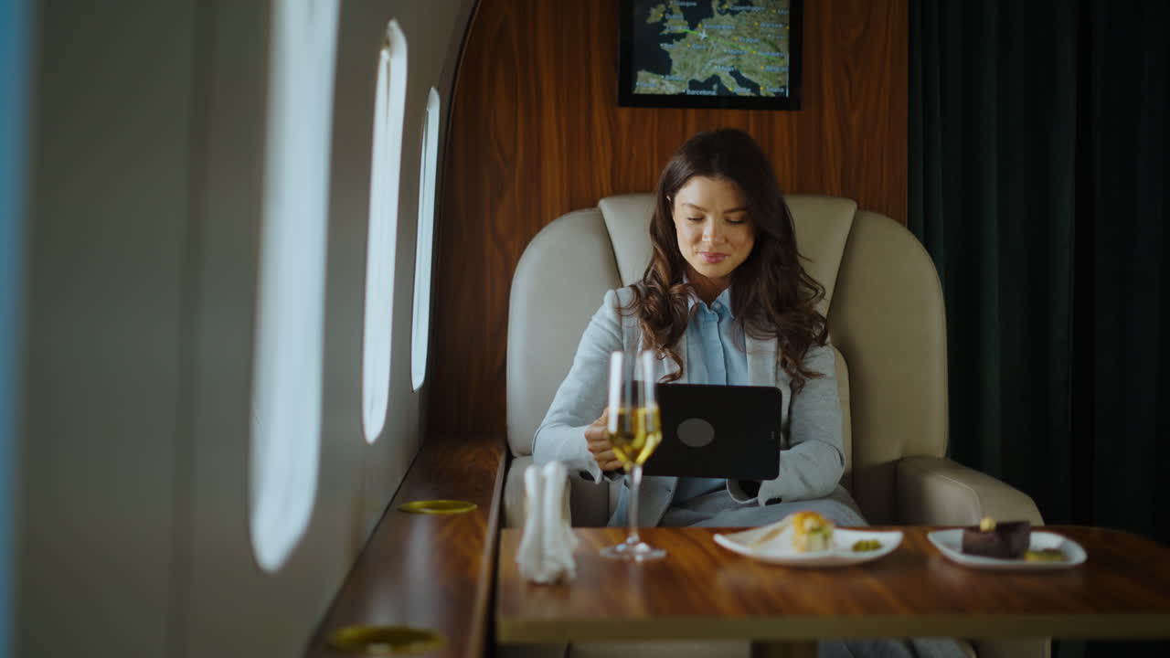 Businesswoman working on tablet in private jet