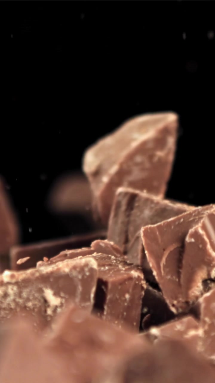 Slow Motion of Chocolate Chunks Falling on a Black Background