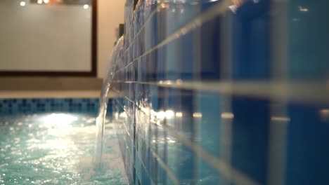 close up view of water flowing from jacuzzi into pool