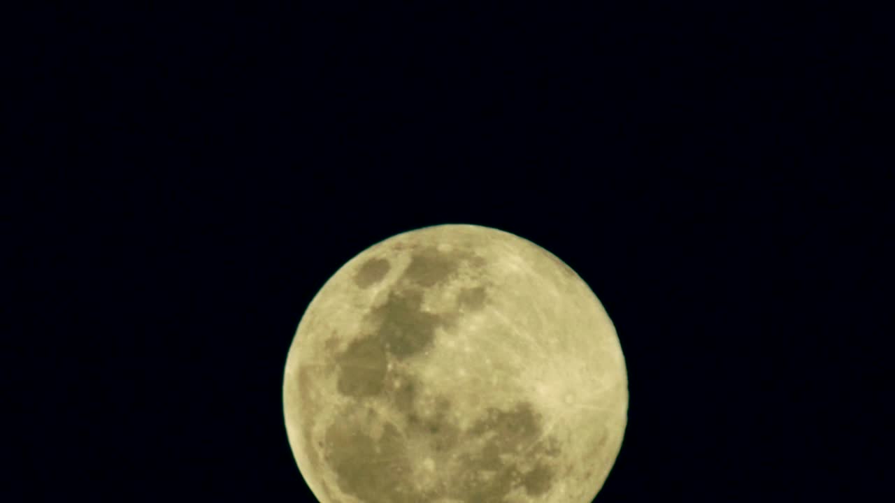 Lua cheia nascente em céu escuro