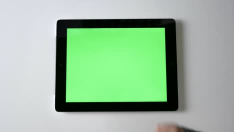children's hands tap on a tablet, green screen, chromakey concept, top shot 60 fps