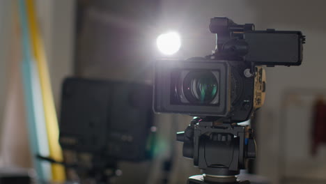 close up of film or video camera on tripod shooting movie or video in studio