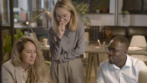 group of three  employees working and talking together in the office